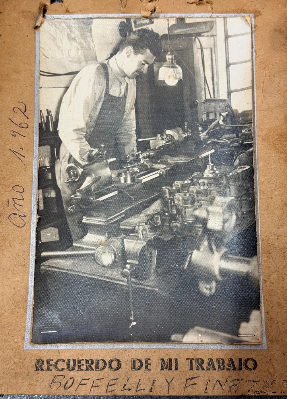 Isidoro Boetto de joven, trabajando en un torno. Foto de 1962 montada en un cartón con la leyenda «Recuerdo de mi trabajo».